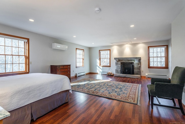 bedroom featuring a baseboard heating unit, dark hardwood / wood-style flooring, and a wall mounted AC