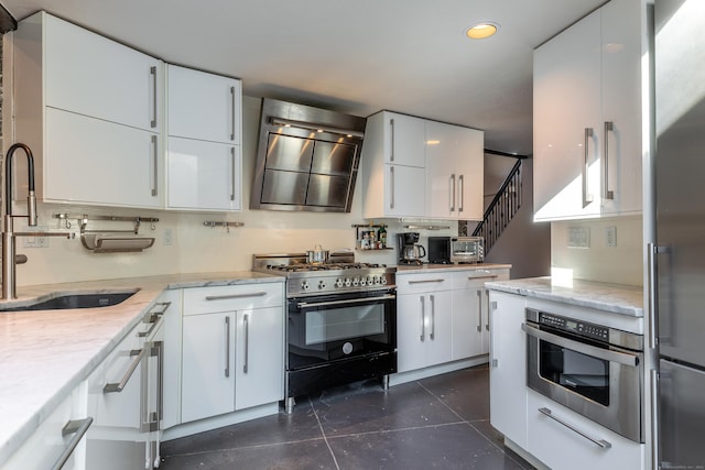 kitchen with extractor fan, appliances with stainless steel finishes, white cabinetry, and sink