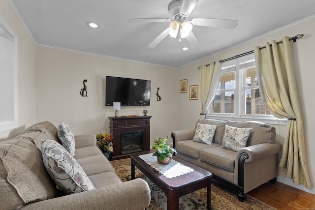 living room featuring ceiling fan, dark parquet flooring, and ornamental molding