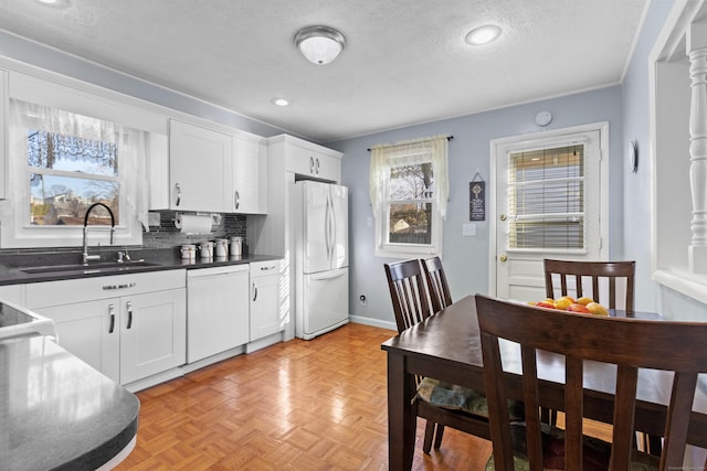 kitchen with decorative backsplash, a textured ceiling, white appliances, sink, and white cabinets