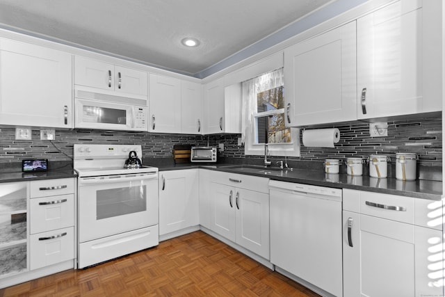 kitchen with white cabinets, dark parquet flooring, white appliances, and decorative backsplash