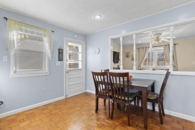 dining room with a textured ceiling, light parquet flooring, and ceiling fan