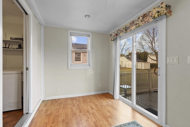 interior space with a healthy amount of sunlight, ornamental molding, and light hardwood / wood-style flooring