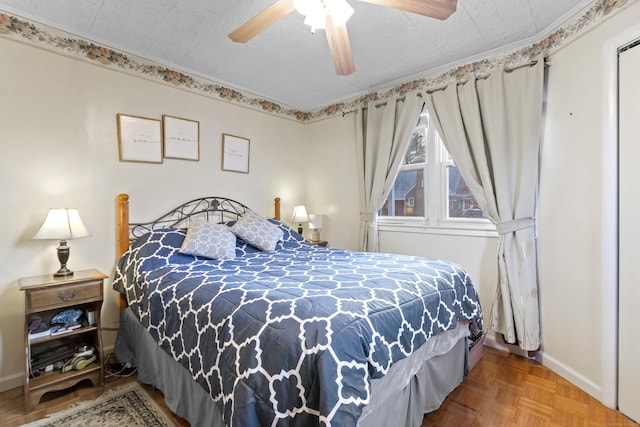 bedroom with ceiling fan, parquet floors, and a textured ceiling