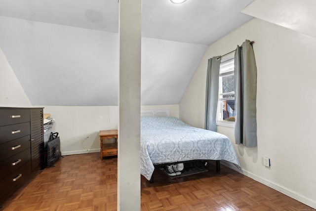 bedroom with light parquet floors and vaulted ceiling