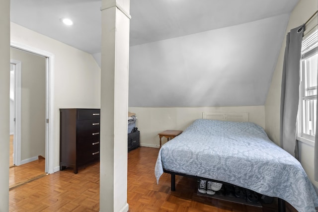 bedroom with lofted ceiling and parquet flooring