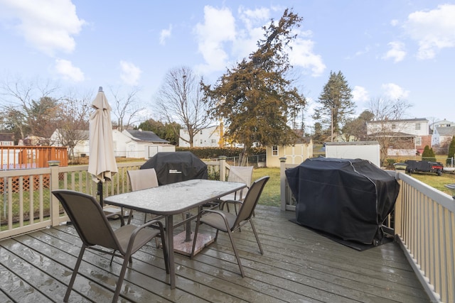 deck with a storage unit and area for grilling