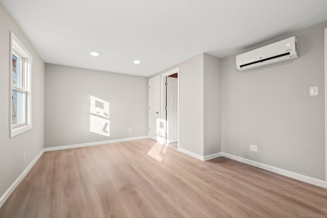 interior space with light hardwood / wood-style flooring and an AC wall unit