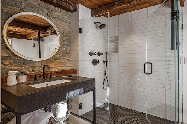 bathroom with a stall shower, wooden ceiling, a sink, and beamed ceiling