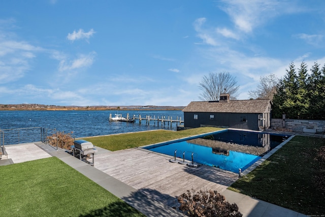 view of pool with area for grilling, a lawn, a water view, and a boat dock