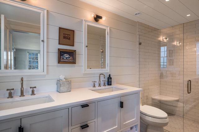 bathroom featuring double vanity, a shower stall, toilet, and a sink