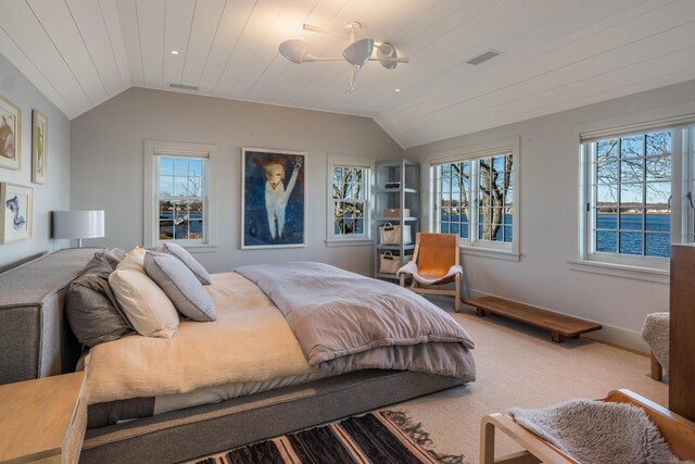 bedroom with a water view, visible vents, carpet flooring, and lofted ceiling