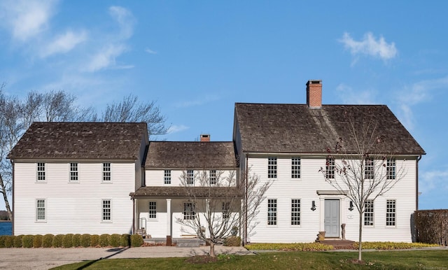 view of front of property with a chimney and a front lawn