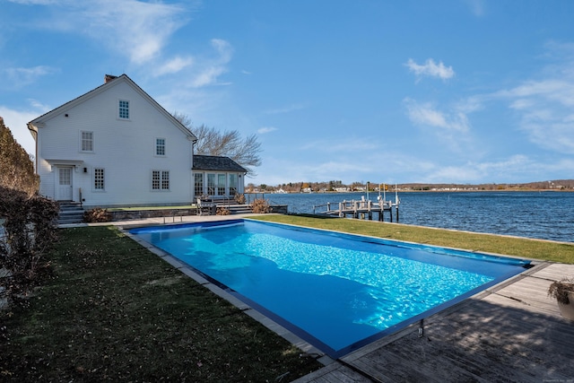 view of swimming pool featuring a yard, a boat dock, and a water view