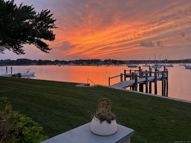 dock area featuring a water view and a lawn