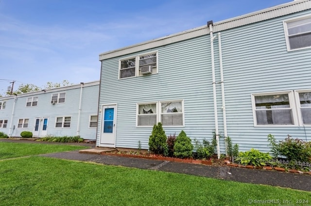 rear view of property with a yard and cooling unit