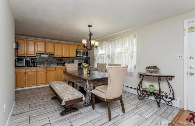 dining space featuring sink, a baseboard radiator, and a chandelier