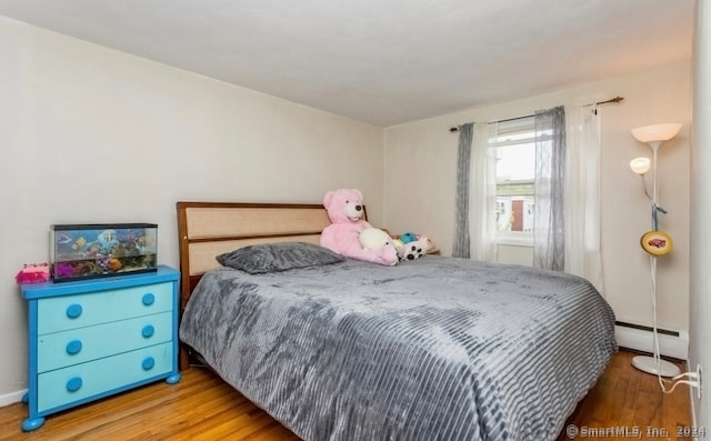 bedroom featuring a baseboard radiator and light wood-type flooring