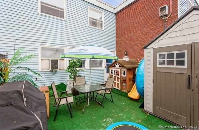 view of patio featuring a shed and a grill