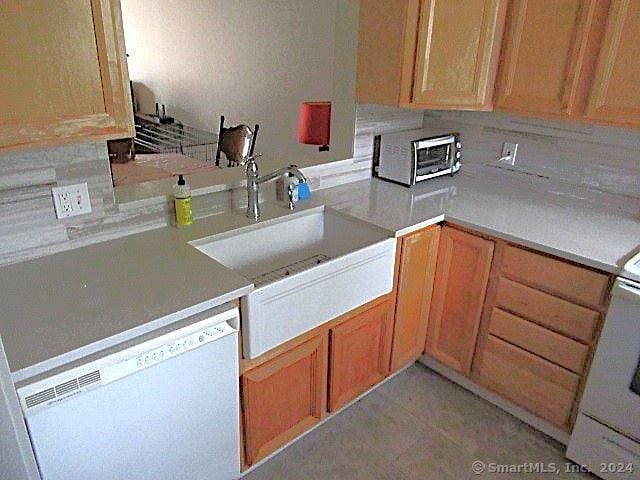 kitchen with dishwasher, sink, and tasteful backsplash