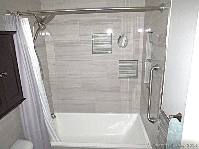 bathroom with shower / bathtub combination with curtain