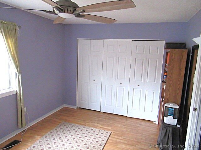 unfurnished bedroom featuring a closet, ceiling fan, and hardwood / wood-style floors