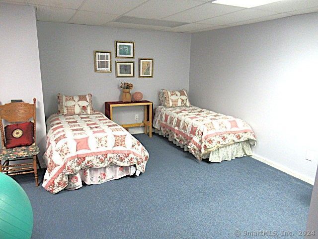 carpeted bedroom featuring a drop ceiling