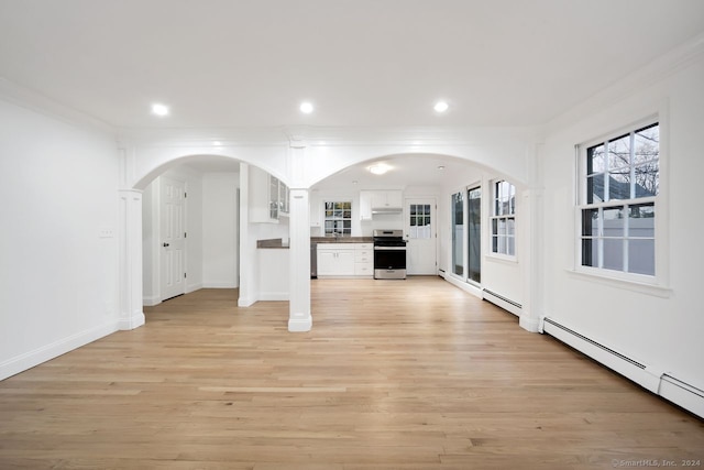 unfurnished living room featuring light wood-type flooring, crown molding, and baseboard heating