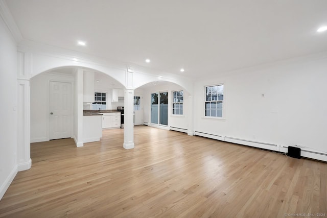 unfurnished living room with light hardwood / wood-style floors and crown molding