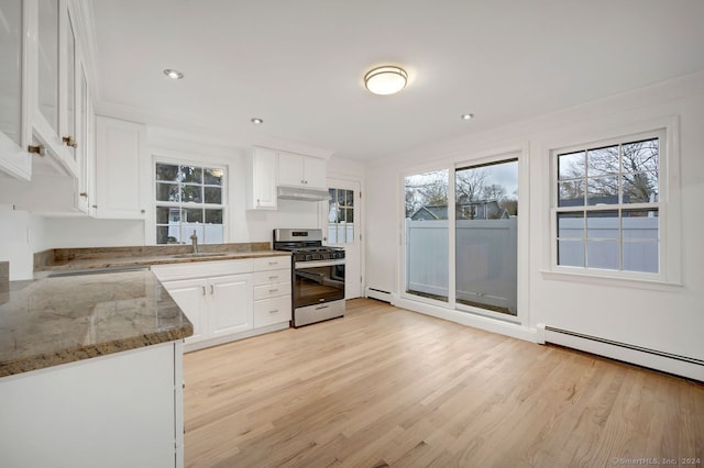 kitchen featuring white cabinets, stone countertops, a wealth of natural light, and stainless steel range with gas stovetop