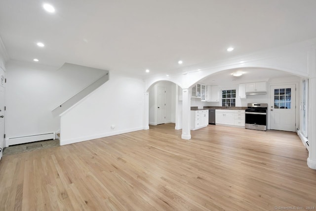 unfurnished living room featuring baseboard heating and light wood-type flooring