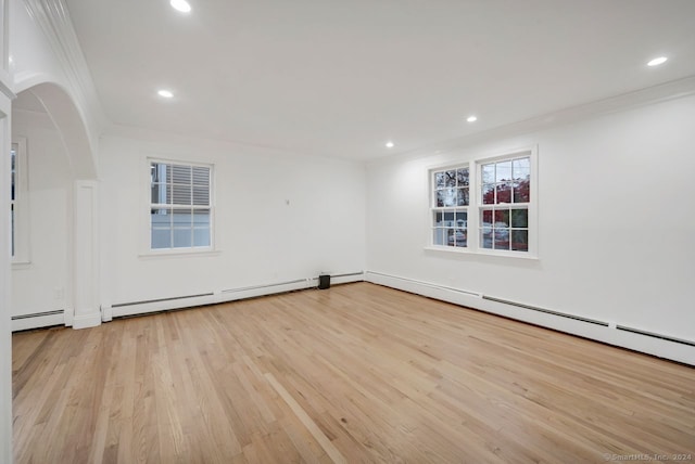 spare room featuring light wood-type flooring, ornamental molding, and a baseboard radiator