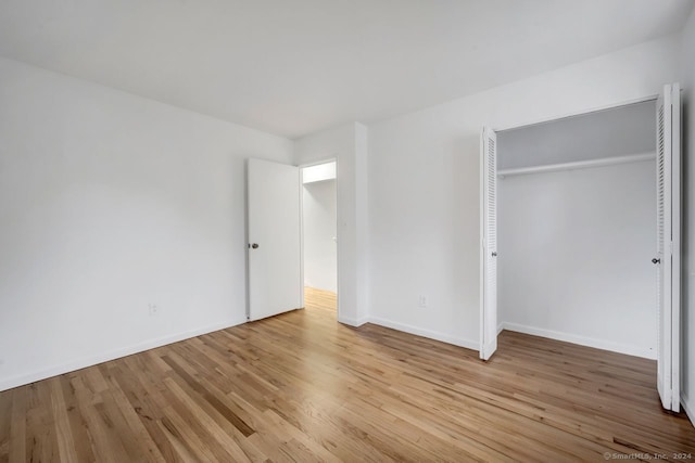 unfurnished bedroom with a closet and light wood-type flooring