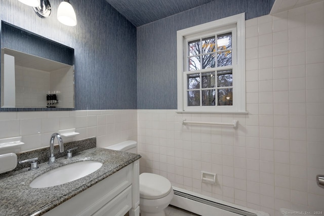 bathroom with vanity, toilet, tile walls, and a baseboard heating unit