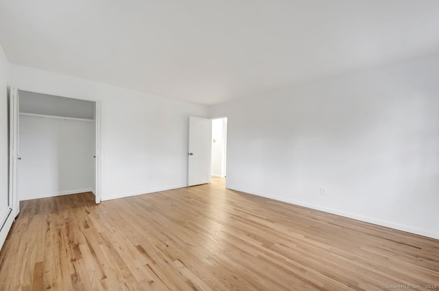 unfurnished bedroom with a closet and light hardwood / wood-style floors