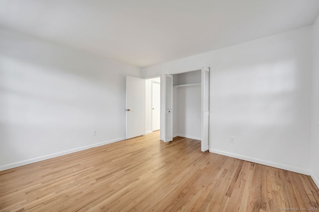 unfurnished bedroom featuring light hardwood / wood-style floors and a closet