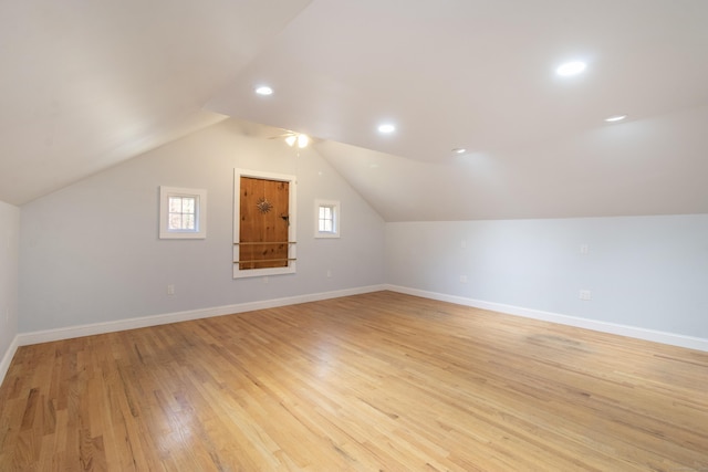 bonus room with baseboards, light wood-style flooring, and lofted ceiling