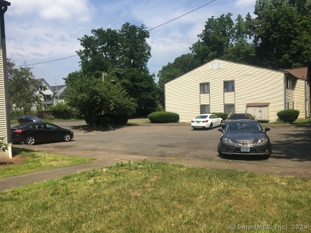 view of parking / parking lot with a lawn