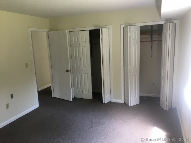 unfurnished bedroom with multiple closets