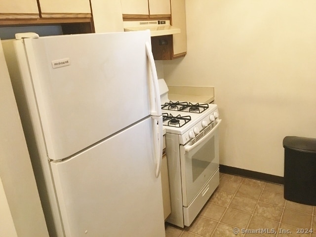 kitchen with white appliances and light tile patterned floors