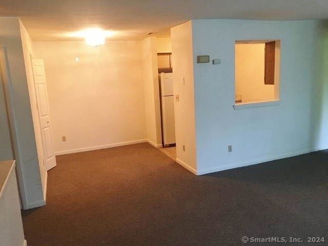 unfurnished room with dark colored carpet