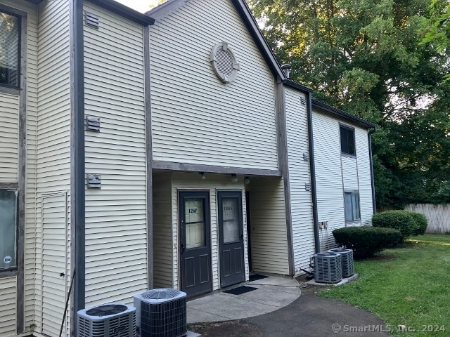 view of property exterior with a yard and central AC