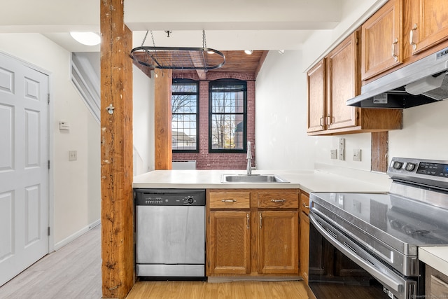 kitchen featuring beamed ceiling, stainless steel appliances, light hardwood / wood-style flooring, and sink