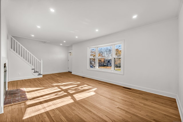 unfurnished living room with light hardwood / wood-style floors and ornamental molding