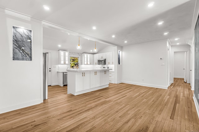 kitchen with white cabinetry, crown molding, decorative light fixtures, a kitchen island, and light wood-type flooring