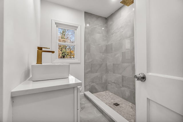 bathroom with tiled shower and sink