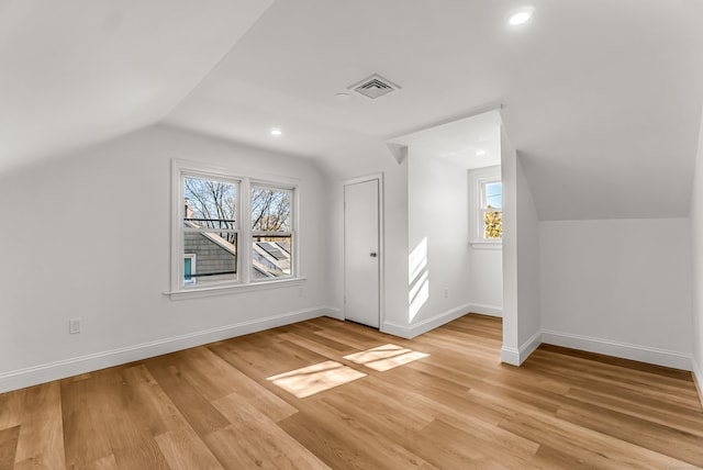 additional living space featuring light hardwood / wood-style flooring and lofted ceiling