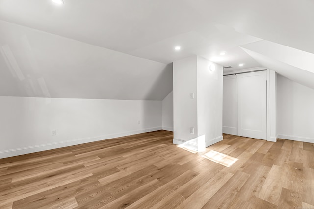 bonus room featuring light wood-type flooring and vaulted ceiling