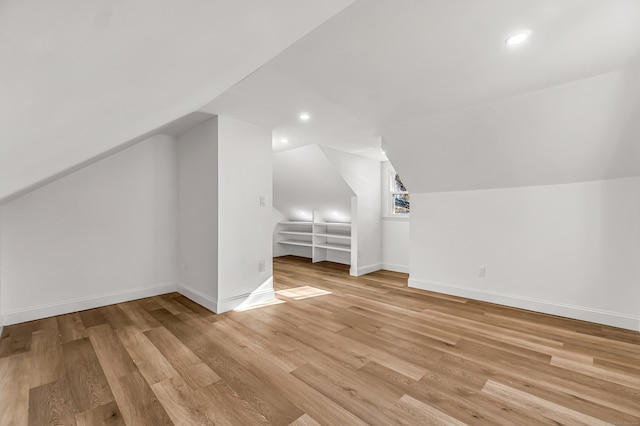 additional living space featuring light hardwood / wood-style floors and lofted ceiling