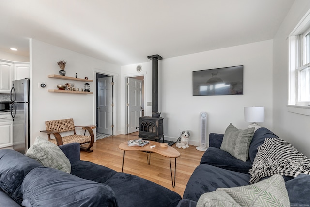 living room featuring light wood-type flooring and a wood stove